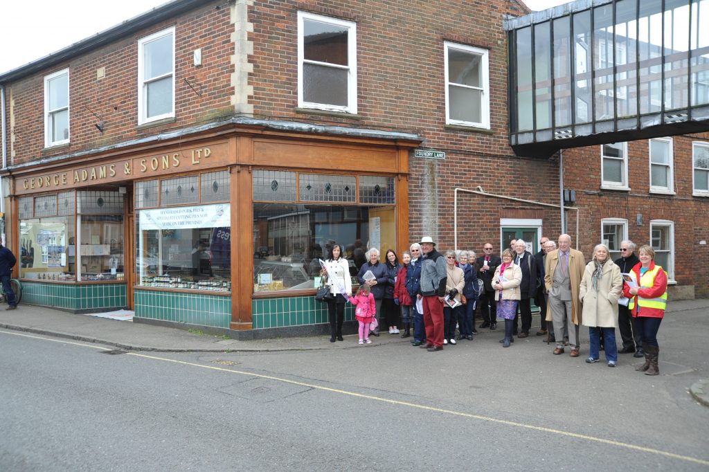 One of the two groups led on a tour of plaques sites last week and (right) Liz and Mary Adams with the cast of them on the side of the family butcher’s shop in The Crescent.